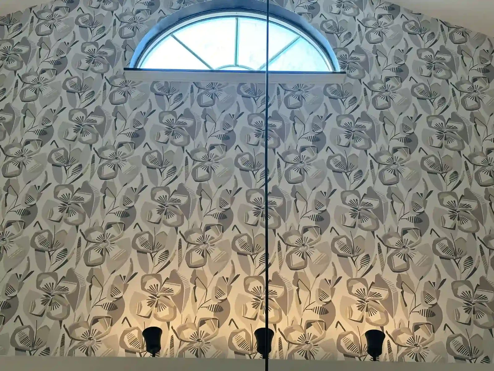 A gray geometric wallcovering meets a large arched window
